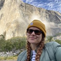 Woman with knit cap posing in front of El Capitan