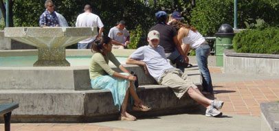 students sitting outside near a fountain