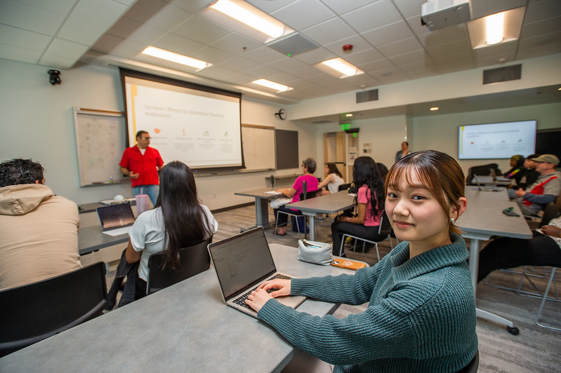student with laptop in a classroom