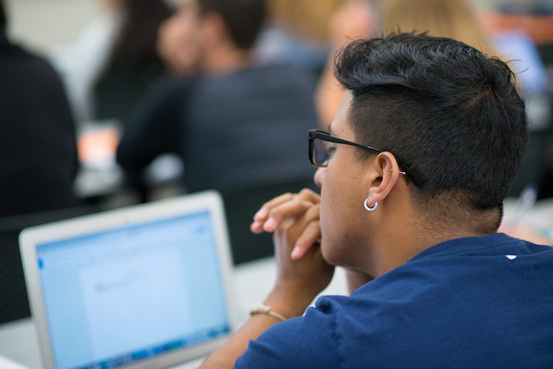 Student with laptop in a classroom