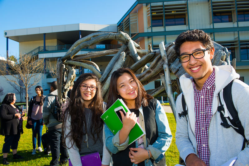 Students holding books smile