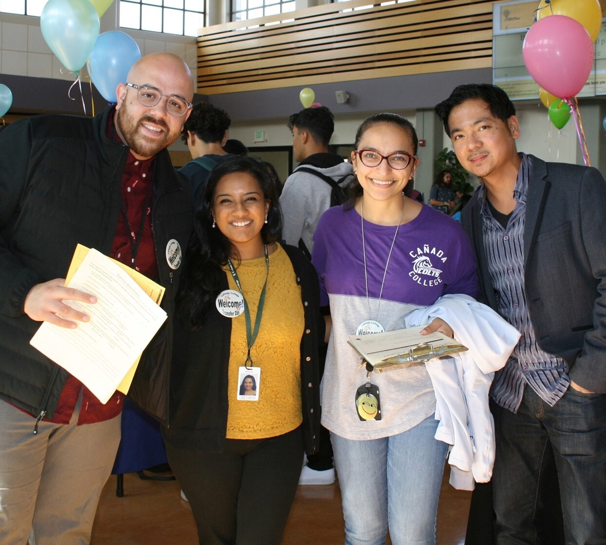 A group of four employees smiles while posing for a photo during Flex Day