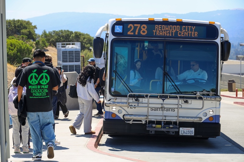 Students getting on a SamTrans bus at the campus bus stop