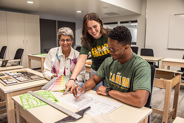 Three Cañada College students collaborating on a classroom design project